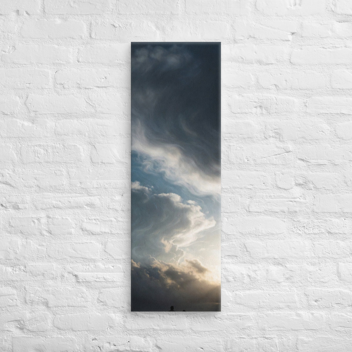 Beneath the Silver Sky, tall wrapped canvas print: two silhouetted figures beneath a vast swirling silver-grey cloudy sky with light breaking through.