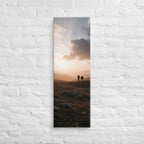 The Last Light Together, tall wrapped canvas print: two figures walking a rocky ridge at sunset, warm golden light over distant mountain peaks.