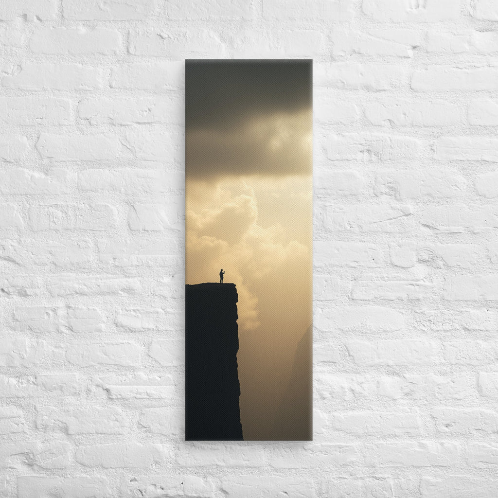 The Edge of Gold, tall wrapped canvas print: a tiny silhouetted figure at the edge of a black cliff against a luminous gold sky.