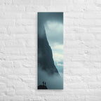 Beside the Mountain Wall, tall wrapped canvas print: two small figures on a rocky ledge beside a towering mist-shrouded mountain wall.