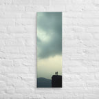 Two at the Horizon, tall wrapped canvas print: two figures at the edge of a cliff under a vast pale grey-green sky, distant mountain ridges.