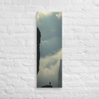 Between the Dark Walls, tall wrapped canvas print: a solitary figure on a rock fin between two sheer dark cliff walls, mist in the gorge.