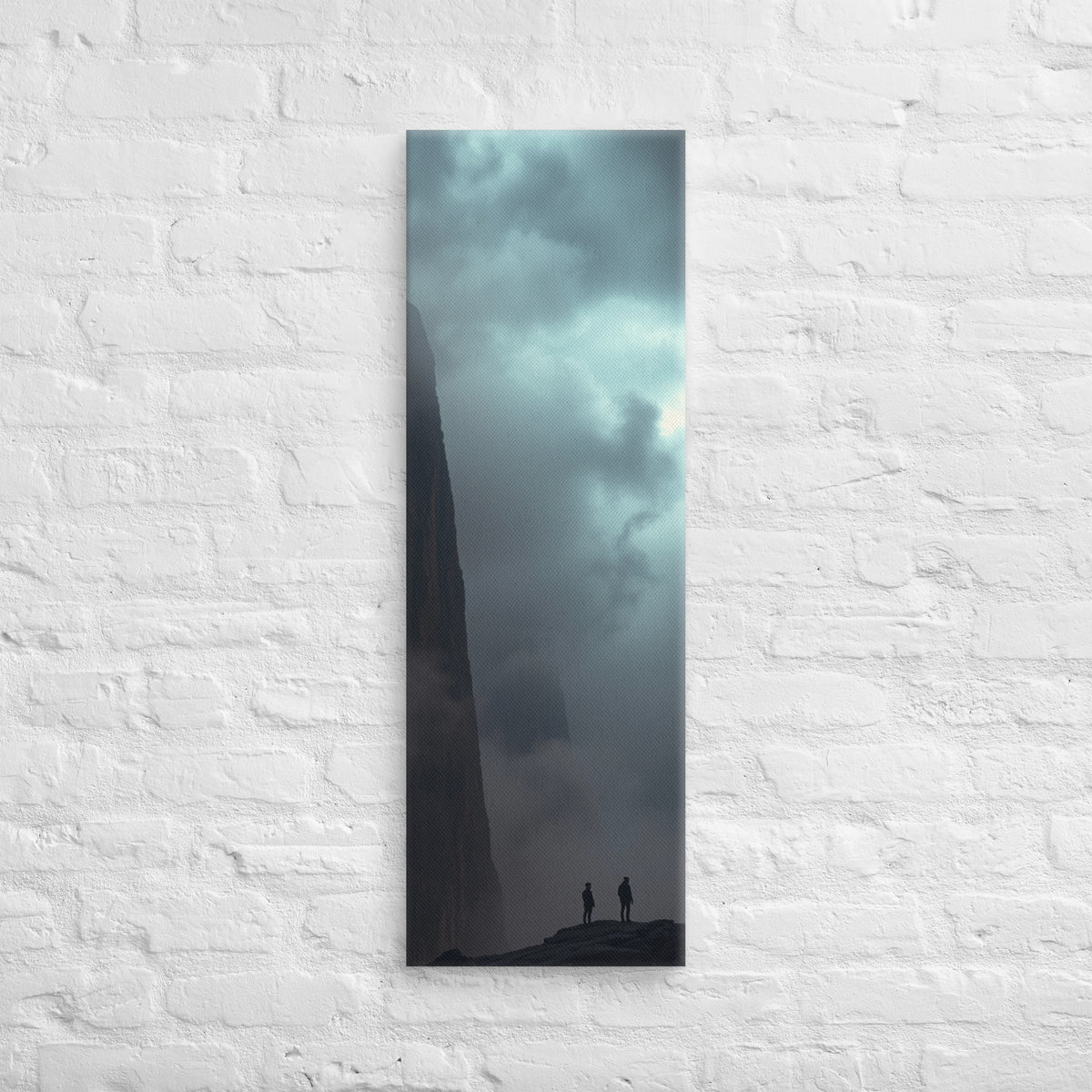 Under the Sheer Wall, tall wrapped canvas print: two small figures beneath a sheer cliff wall rising into cloud.
