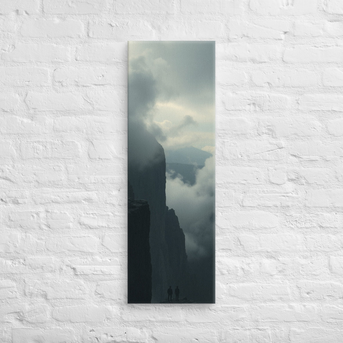 The Clouded Chasm, tall wrapped canvas print: two figures on a dark pinnacle above a chasm of churning cloud between sheer walls.