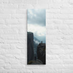 Across the Divide, tall wrapped canvas print: two figures on separate rocky outcrops with a misty mountain divide between them.