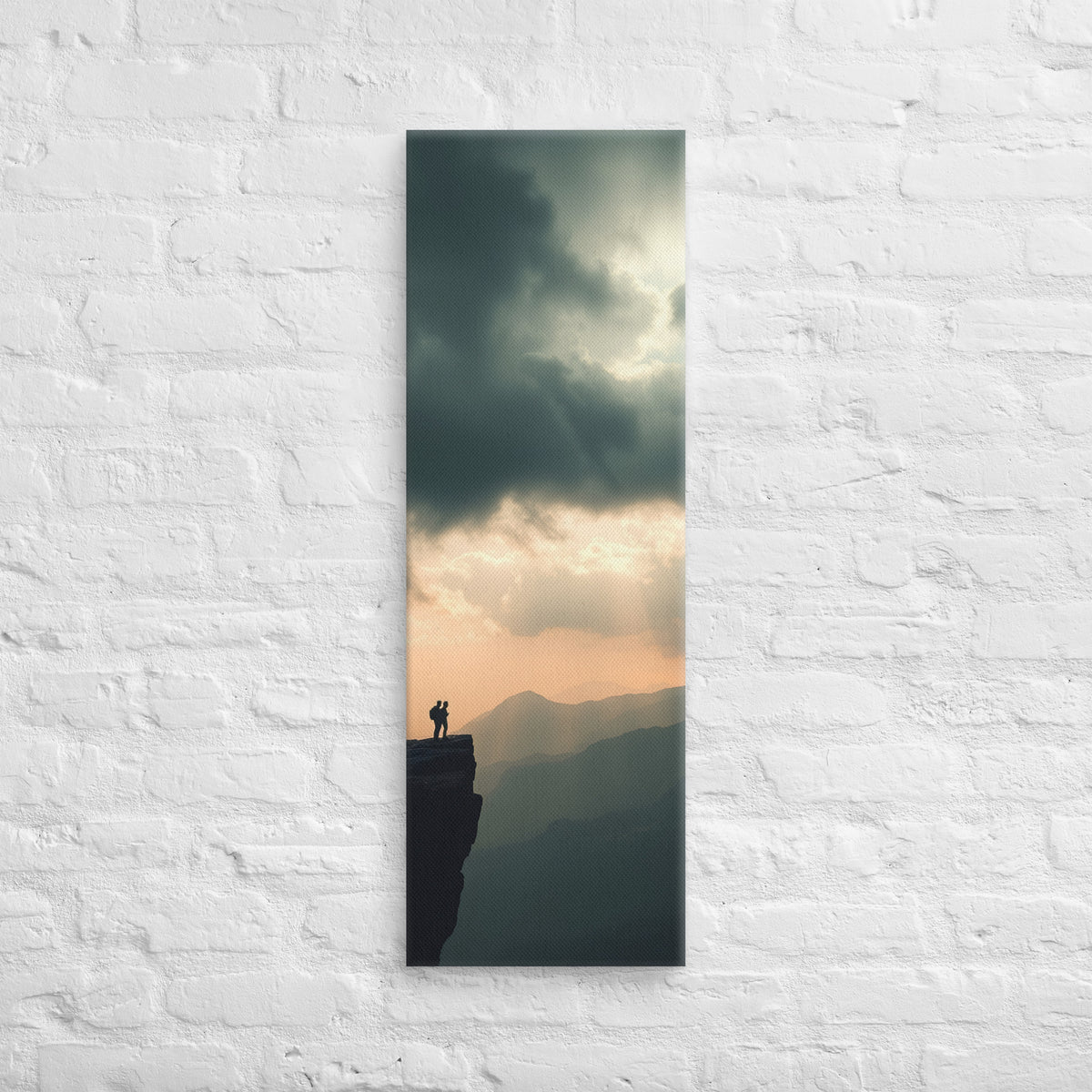 The Amber Distance, tall wrapped canvas print: two figures on a cliff edge facing an amber sunset sky with light rays over layered ridges.