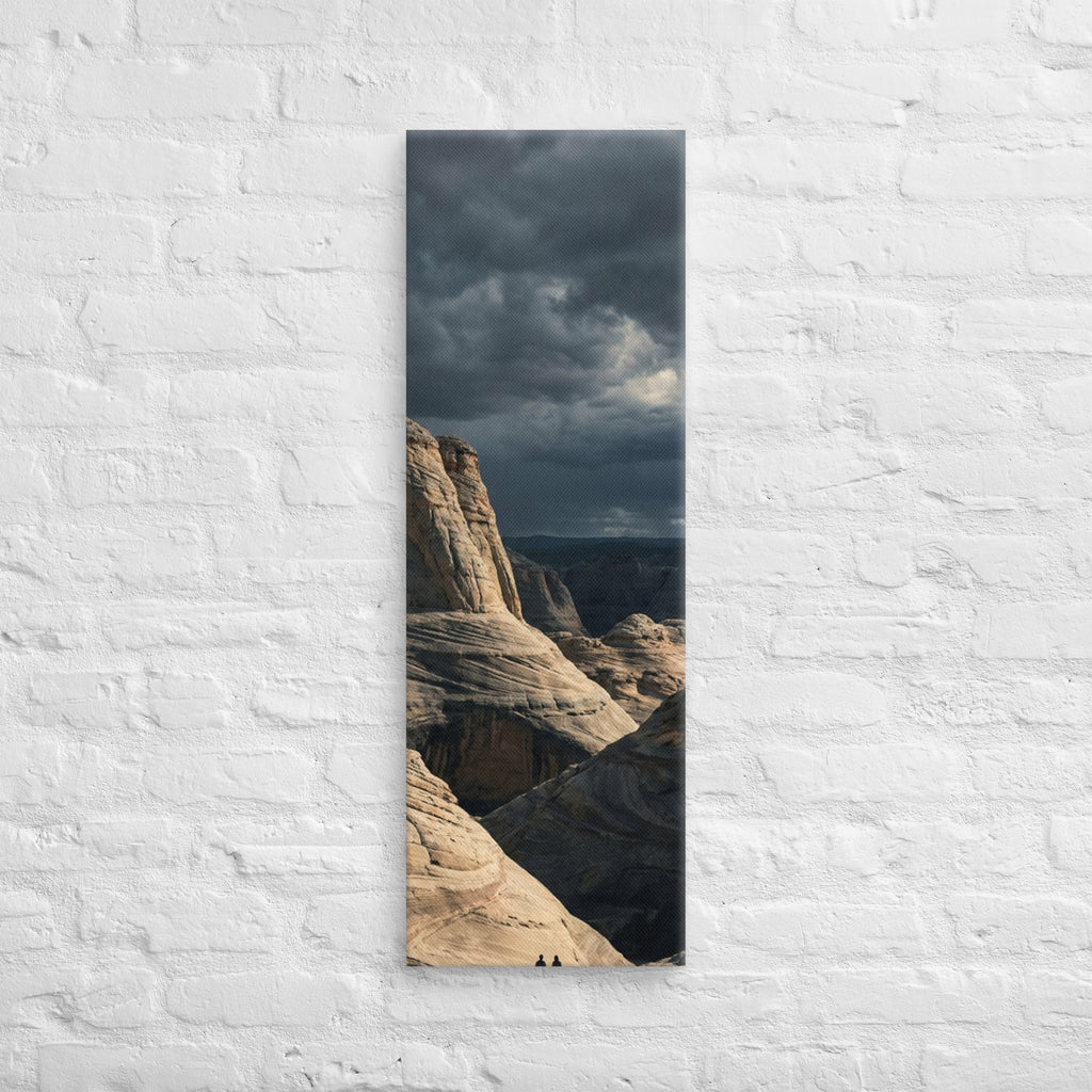 Among the Sandstone Folds, tall wrapped canvas print: two figures among pale wave-folded sandstone formations under a dark sky.