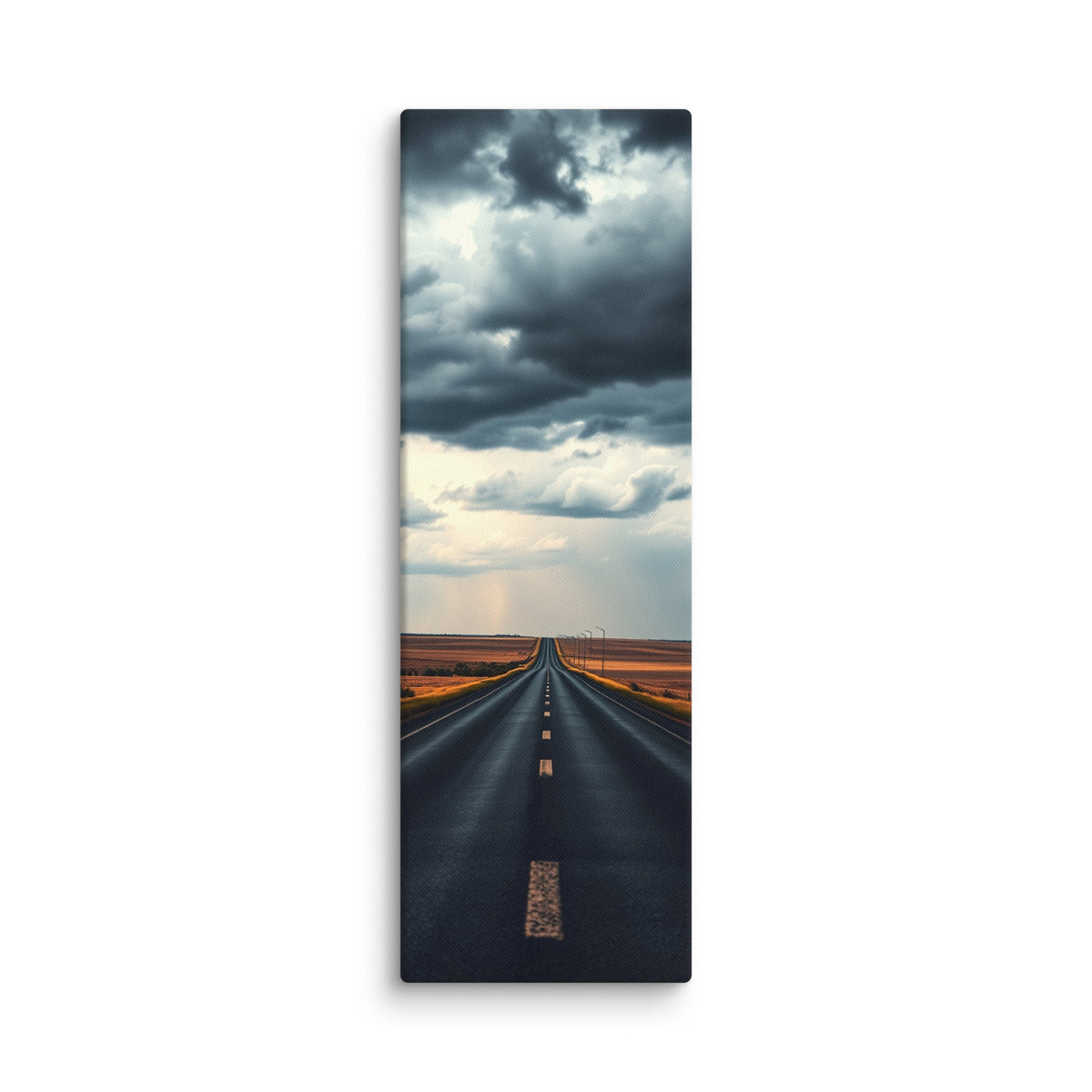 Before The Rain, tall wrapped canvas print: a straight road through amber fields under towering dark storm clouds, rain falling in the distance.