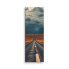 Where The Sky Breaks, tall wrapped canvas print: a road across golden plains toward a dark storm wall with a shaft of light breaking through.