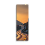 Borrowed Fire, tall wrapped canvas print: a switchback mountain road at golden hour with the asphalt catching warm fire-gold light.