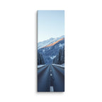 The Last Warm Ridge, tall wrapped canvas print: a road between snowy pines toward a snow peak catching the last warm alpenglow.