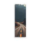 Beneath The Dark Summit, tall wrapped canvas print: a winding road through a dark mountain valley beneath brooding blue-grey peaks.