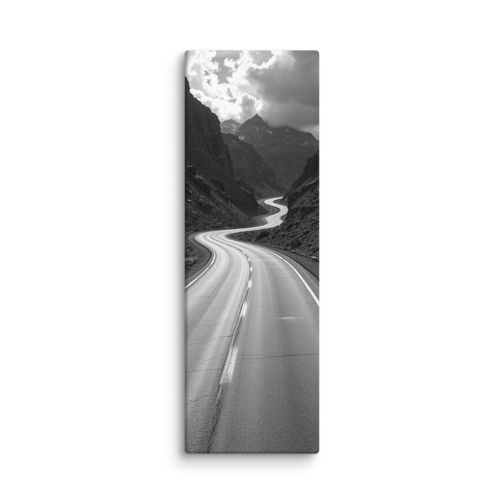 Silver Through Stone, tall wrapped canvas print: a black-and-white serpentine road winding through a rocky mountain gorge beneath dramatic clouds.