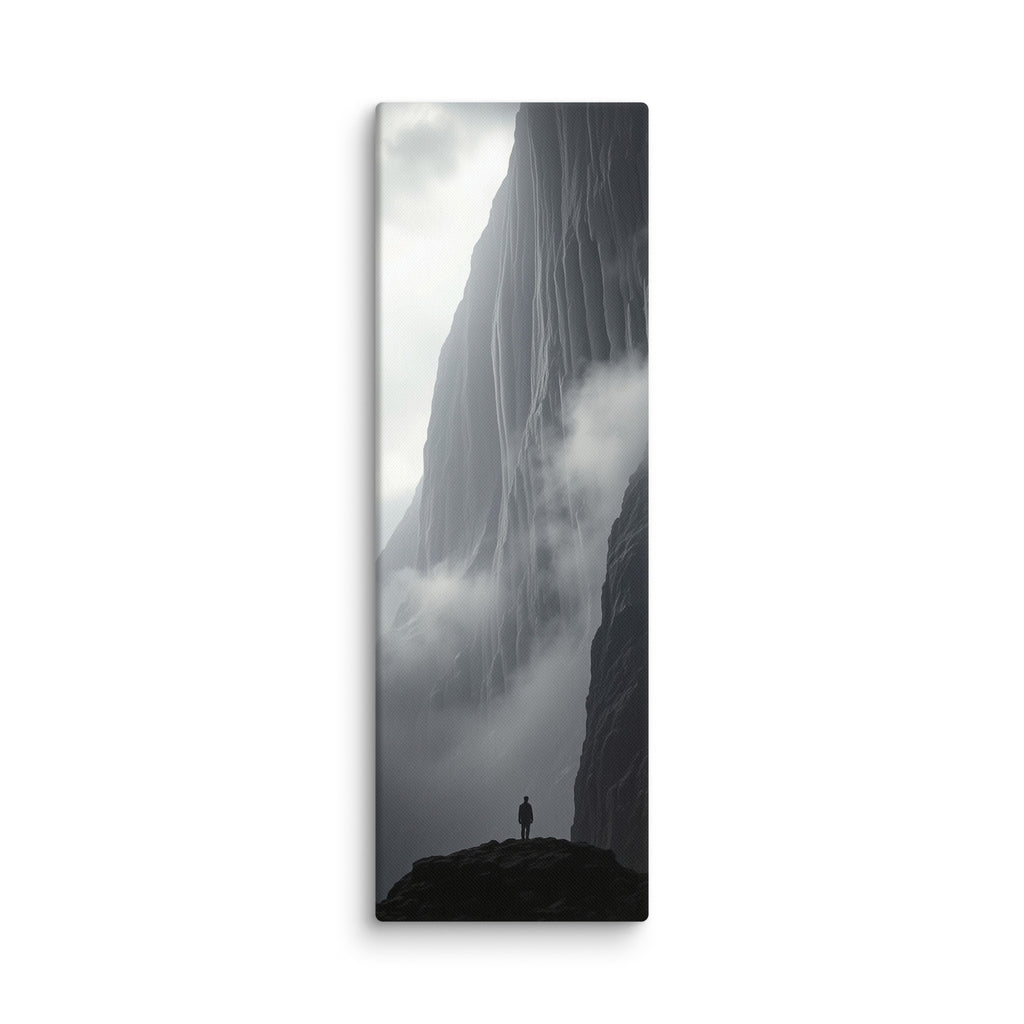 Between Earth And Cloud, tall wrapped canvas print: black-and-white image of a lone figure on a dark outcrop between mist-shrouded ice cliffs.