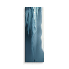 Blue Suspension, tall wrapped canvas print: a lone figure before a blue frozen waterfall hung with icicles, bright light at its edge.