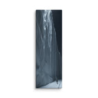 Nightfall Cascade, tall wrapped canvas print: a glowing blue frozen waterfall wall at night with a lone figure and footprints in the snow.