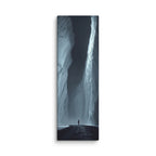 The Dark Reach, tall wrapped canvas print: a lone figure on dark ice between towering ice walls with light falling down one face.