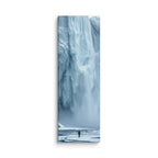 Water Held In Time, tall wrapped canvas print: a lone figure on a frozen river before a massive blue icefall with dark open water.