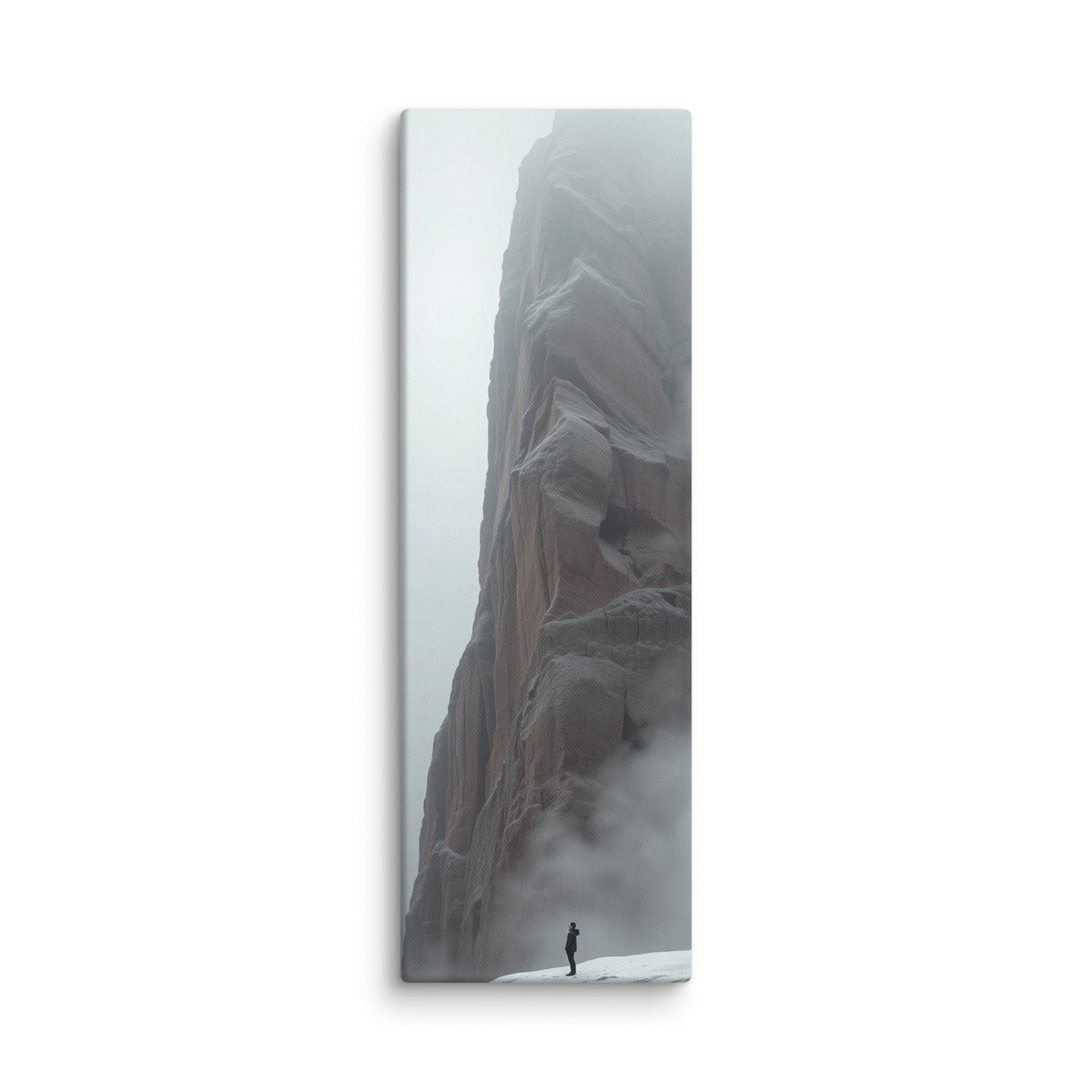 Winter Keeps Watch, tall wrapped canvas print: a lone figure standing on snow before a towering grey rock spire dissolving into fog.