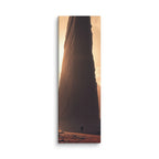 Before The First Light, tall wrapped canvas print: a lone figure before a colossal dark monolith with golden dawn light behind it.