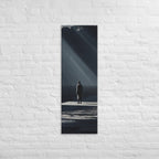 In a Shaft of Light, tall wrapped canvas print: a lone figure at the water's edge beneath dramatic shafts of light breaking through dark clouds.