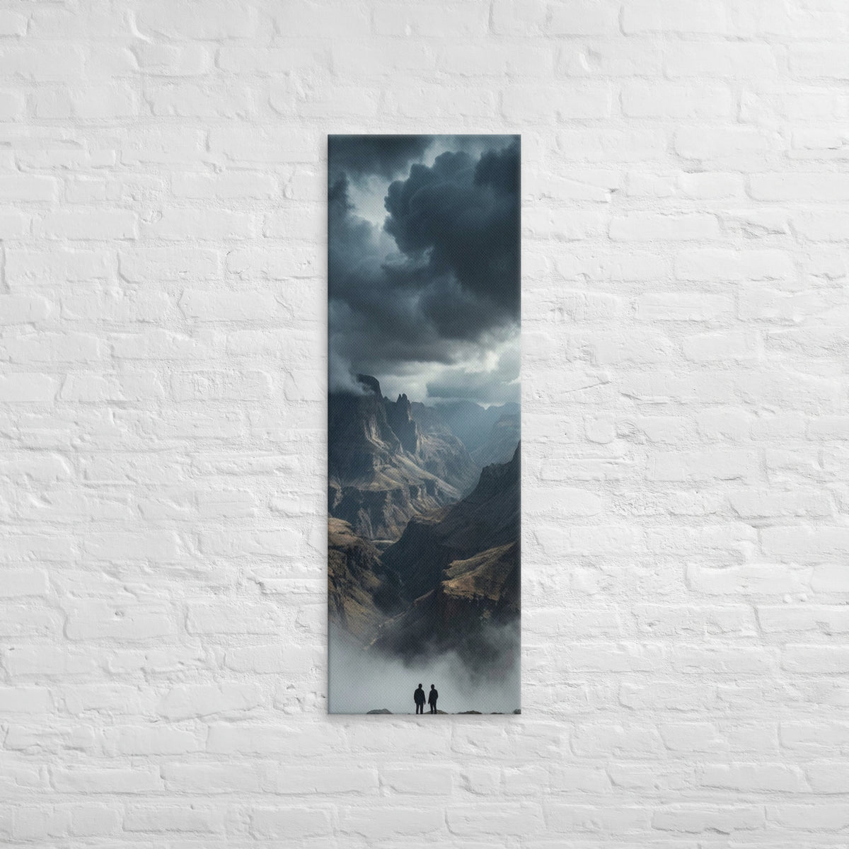 The Valley Below, tall wrapped canvas print: two figures on rocks looking down into a misty valley of dark storm-capped peaks.