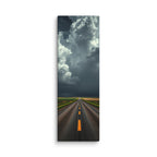 The Gathering Sky, tall wrapped canvas print: an immense white cumulus cloud building over a road through green fields, dark weather behind it.