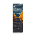 The Last Turn Of Autumn, tall wrapped canvas print: a winding road through golden autumn trees toward a dark mountain under heavy storm clouds.