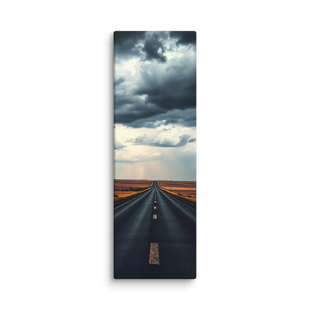 Before The Rain, tall wrapped canvas print: a straight road through amber fields under towering dark storm clouds, rain falling in the distance.