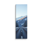 The Last Warm Ridge, tall wrapped canvas print: a road between snowy pines toward a snow peak catching the last warm alpenglow.