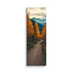Through Amber Woods, tall wrapped canvas print: a curving dirt road through golden autumn trees toward snow-capped mountains.