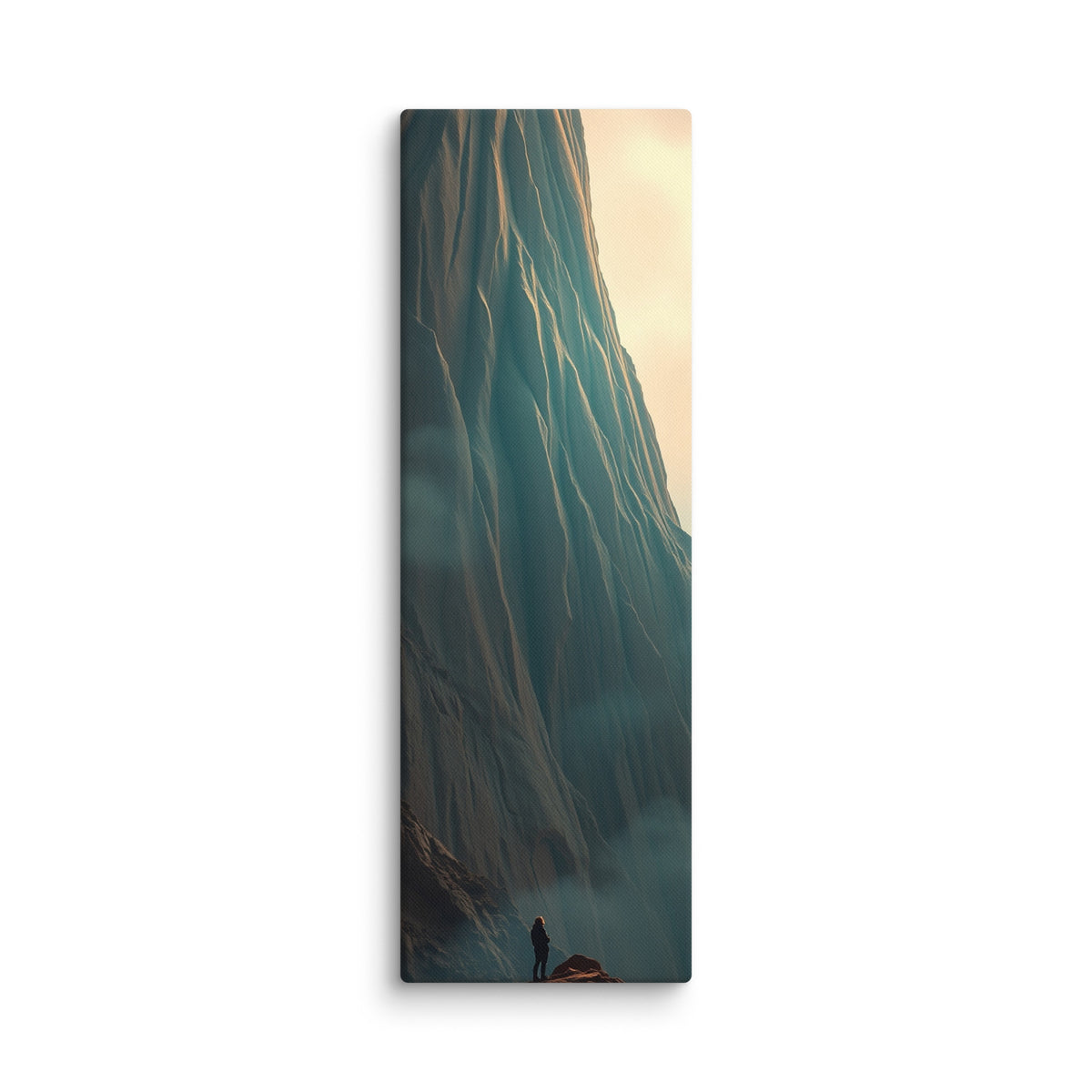 The Long Ascent, tall wrapped canvas print: a lone figure on a rocky peak looking up at a colossal striated cliff face.