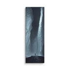 The Dark Reach, tall wrapped canvas print: a lone figure on dark ice between towering ice walls with light falling down one face.