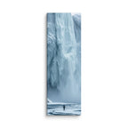 Water Held In Time, tall wrapped canvas print: a lone figure on a frozen river before a massive blue icefall with dark open water.