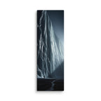 Where Light Breaks, tall wrapped canvas print: a lone figure before a vast ice cliff at night with a shaft of light breaking through on the right.