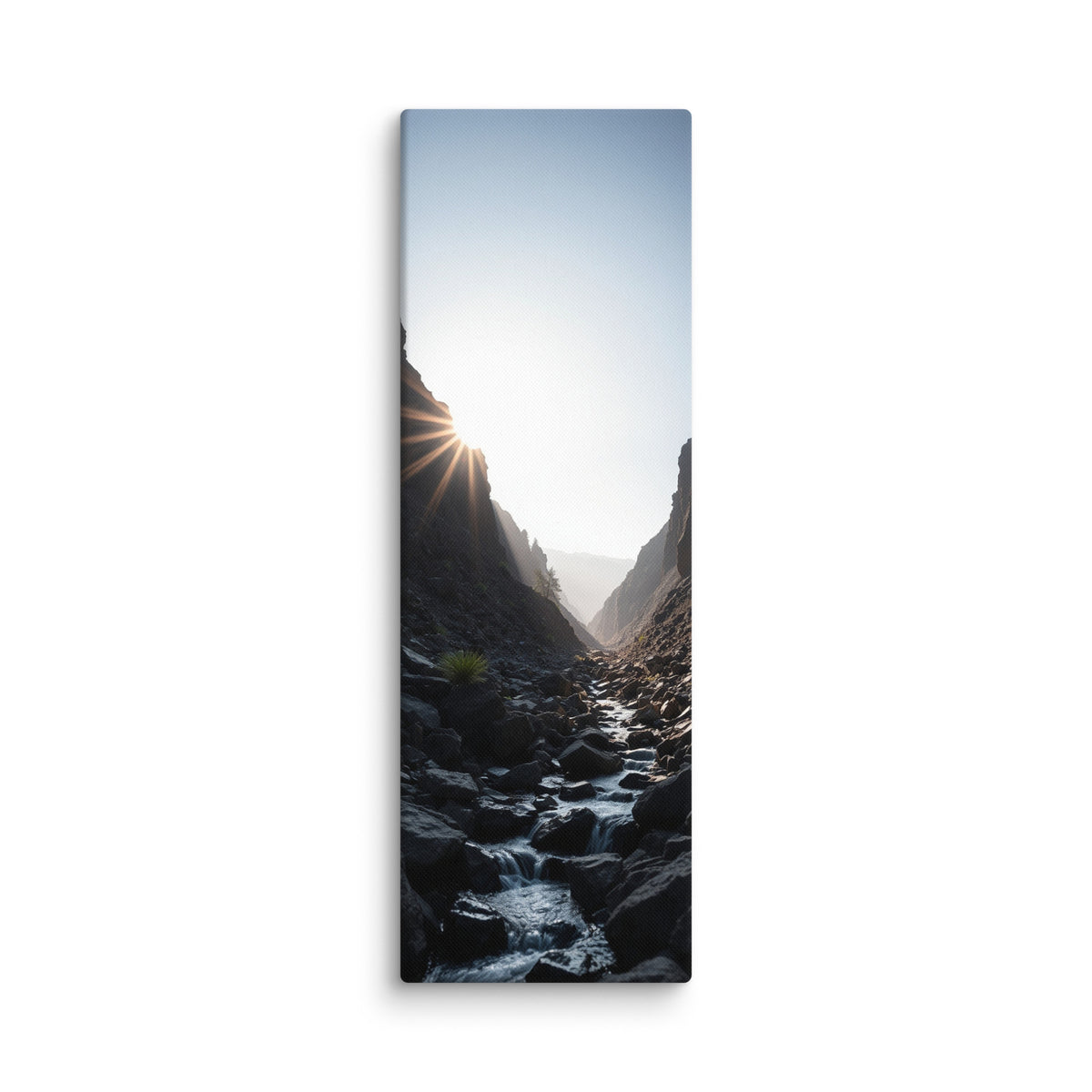 First Light In The Cleft, tall wrapped canvas print: the sun bursting over a dark rocky cleft as a stream flows toward the light.