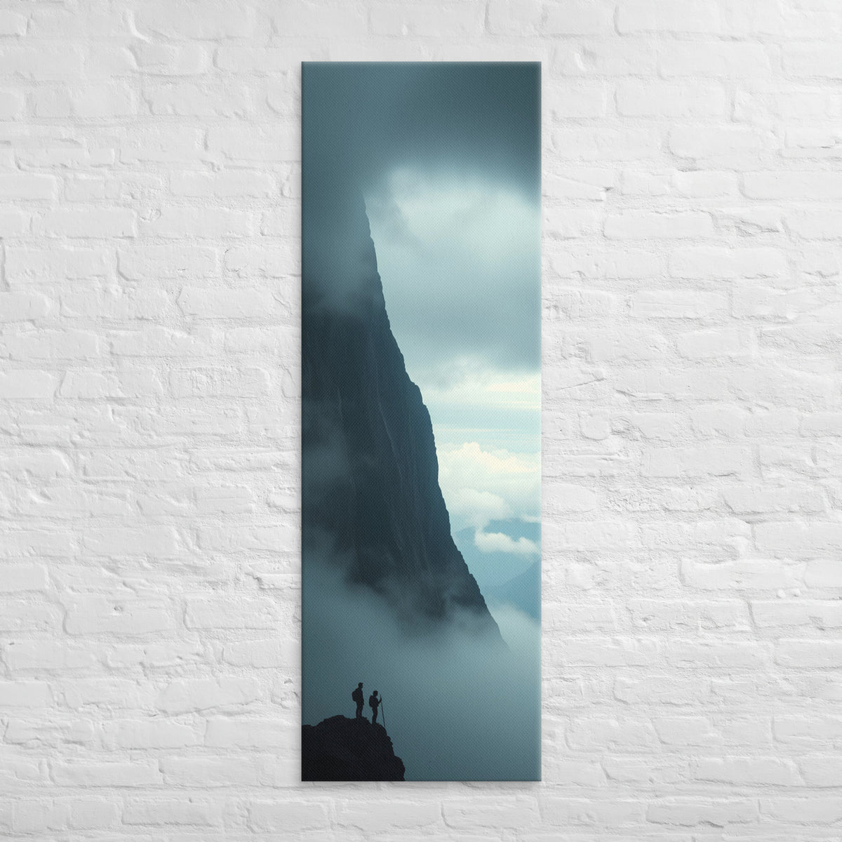 Beside the Mountain Wall, tall wrapped canvas print: two small figures on a rocky ledge beside a towering mist-shrouded mountain wall.