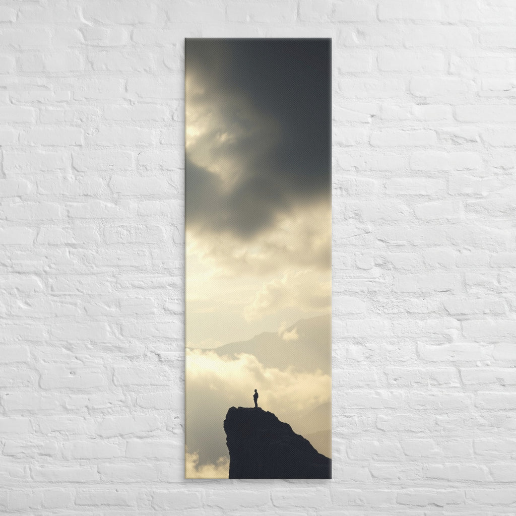 A Summit in Light, tall wrapped canvas print: a lone figure atop a dark rocky summit with radiant light breaking through clouds.