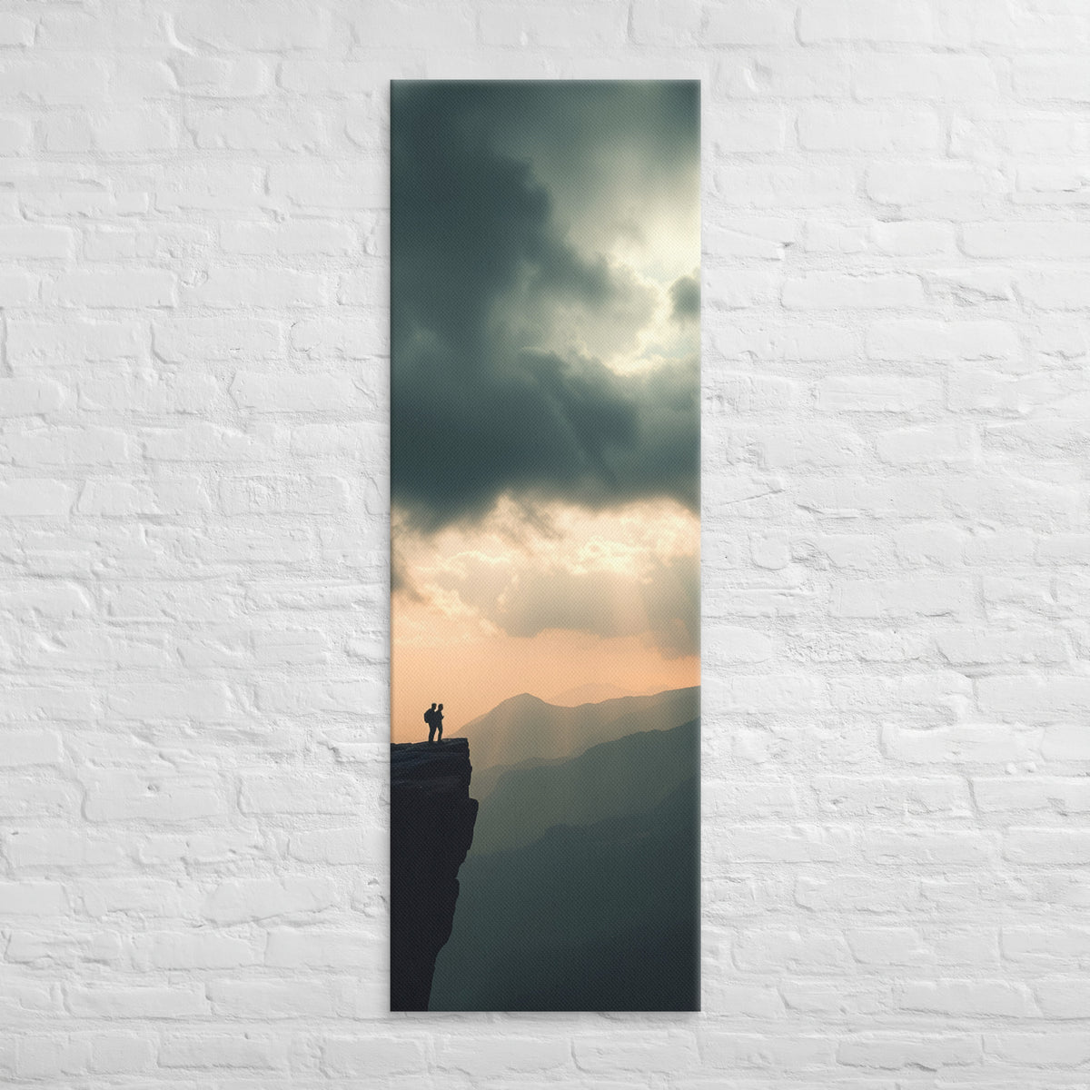 The Amber Distance, tall wrapped canvas print: two figures on a cliff edge facing an amber sunset sky with light rays over layered ridges.
