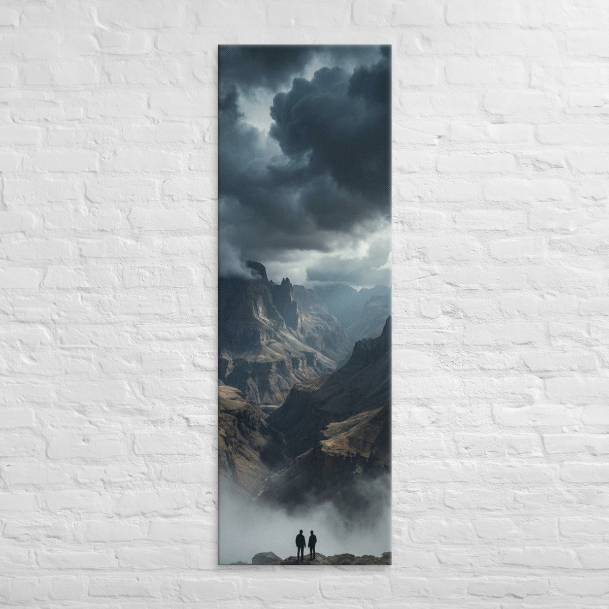 The Valley Below, tall wrapped canvas print: two figures on rocks looking down into a misty valley of dark storm-capped peaks.