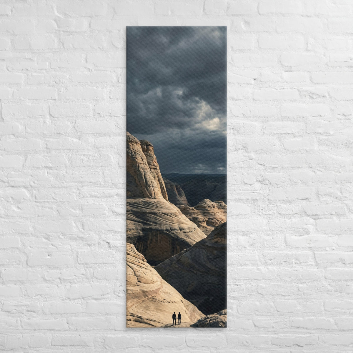 Among the Sandstone Folds, tall wrapped canvas print: two figures among pale wave-folded sandstone formations under a dark sky.