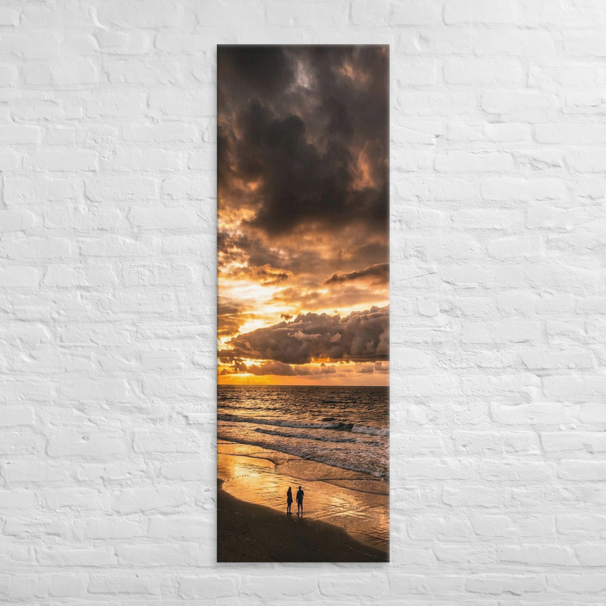 Two at the Tide, tall wrapped canvas print: two figures on wet sand under a fiery orange sunset over the sea.