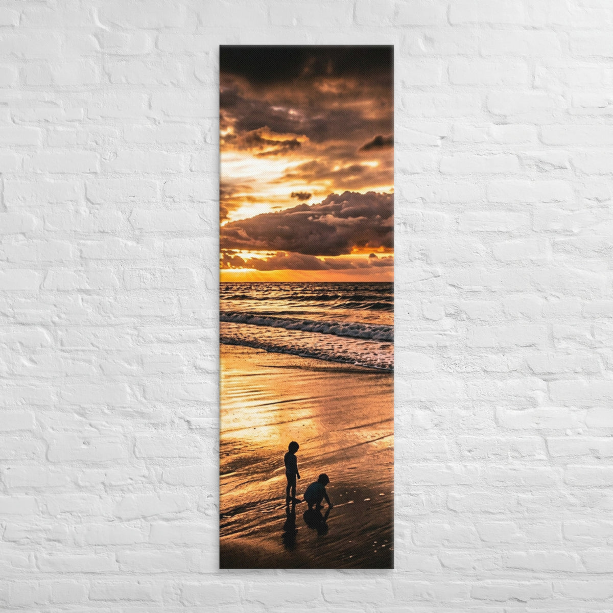 At the Water's Edge, tall wrapped canvas print: two figures on wet sand at the water's edge under a blazing golden sunset.