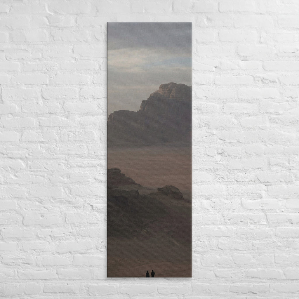 The Desert Stillness, tall wrapped canvas print: three figures in a vast hazy desert with a lone mesa in the distance.