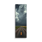The Gathering Sky, tall wrapped canvas print: an immense white cumulus cloud building over a road through green fields, dark weather behind it.