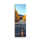 The Amber Turn, tall wrapped canvas print: a straight road through golden aspen trees under a clear blue sky, dappled sunlight on asphalt.
