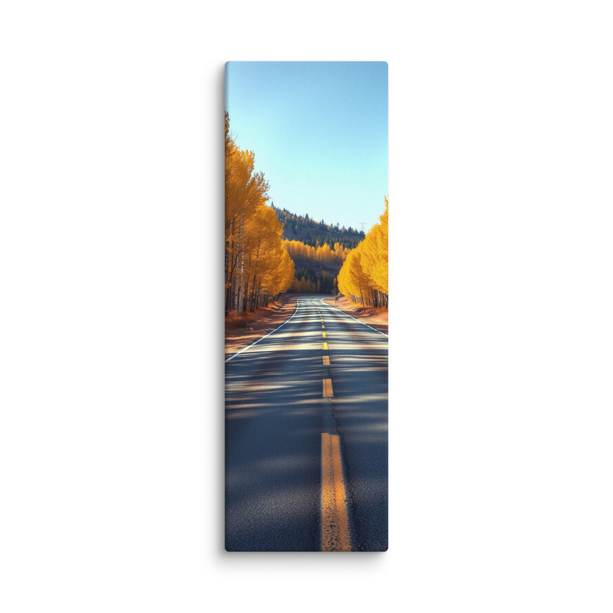 The Amber Turn, tall wrapped canvas print: a straight road through golden aspen trees under a clear blue sky, dappled sunlight on asphalt.