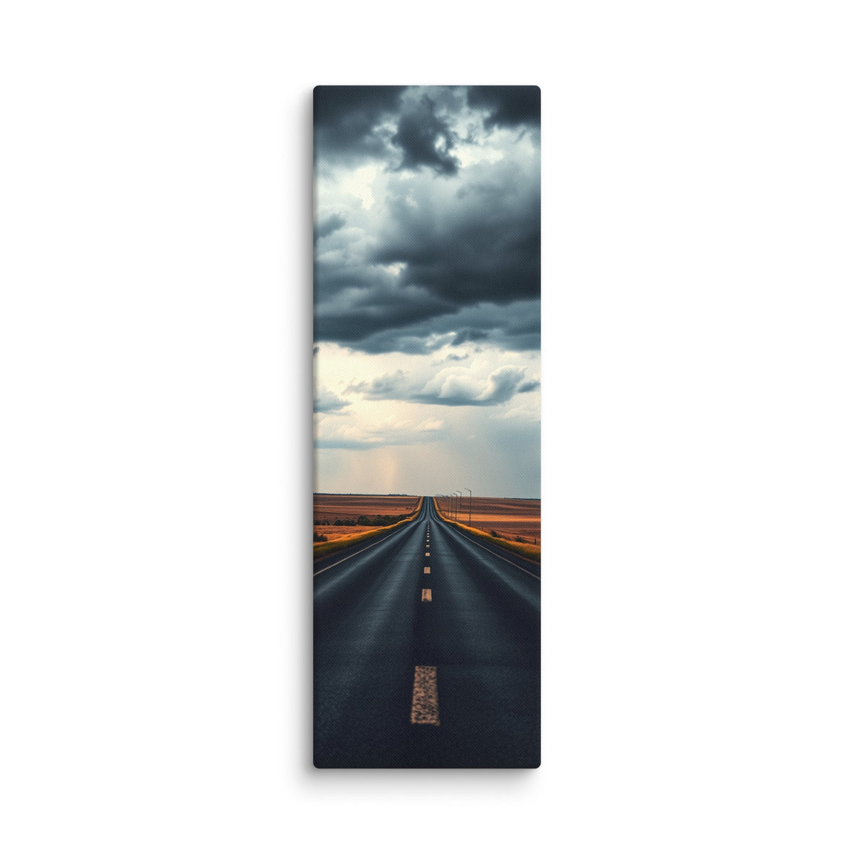 Before The Rain, tall wrapped canvas print: a straight road through amber fields under towering dark storm clouds, rain falling in the distance.