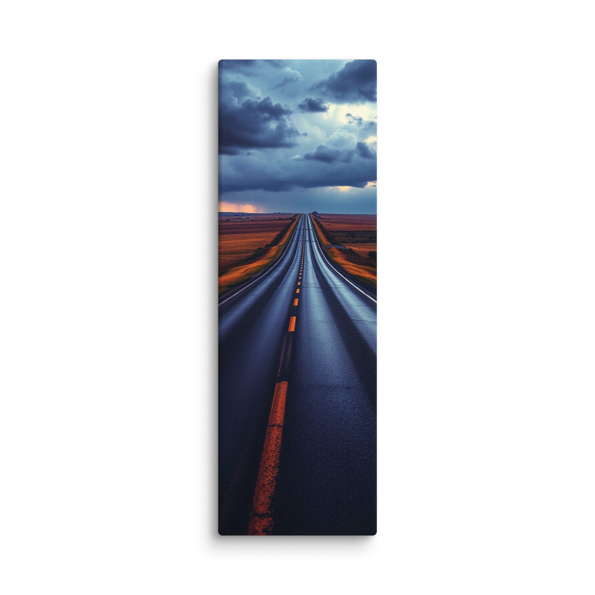 The Blue Before Night, tall wrapped canvas print: a wet road across russet plains beneath massive bruised-blue storm clouds with amber light on the horizon.
