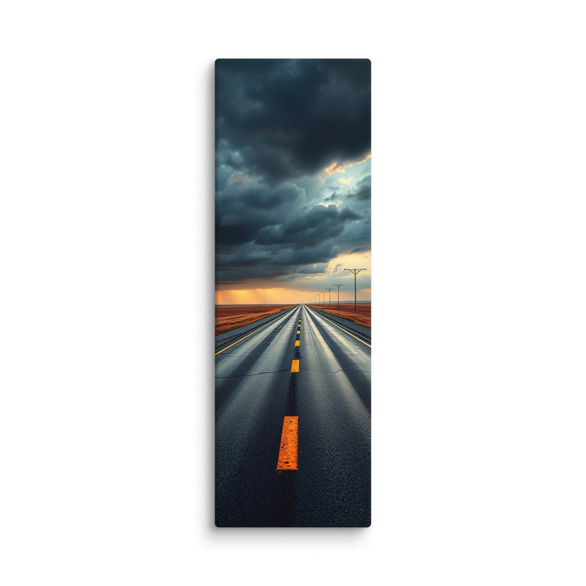 At The Edge Of The Storm, tall wrapped canvas print: a long straight road across russet plains under massive dark storm clouds with amber sunset light on the horizon.